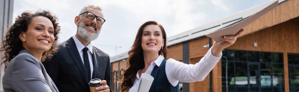 Sonrientes Socios Negocios Multiétnicos Mirando Hacia Otro Lado Cerca Bienes — Foto de Stock