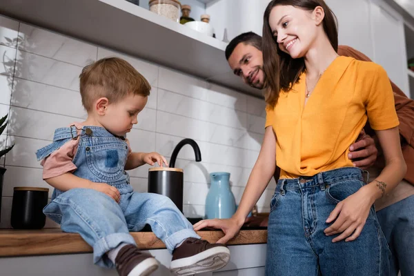 Criança Sentada Bancada Cozinha Perto Pais Positivos — Fotografia de Stock