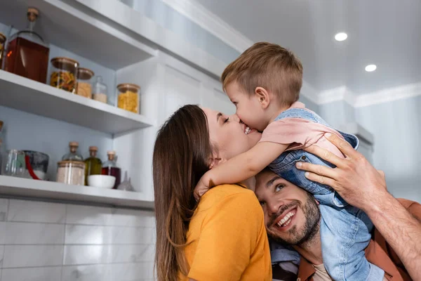 Leende Kvinna Kysser Son Nära Make Hemma — Stockfoto