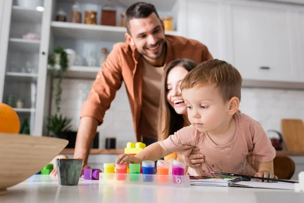 Kleinkind Nimmt Farbe Der Nähe Von Bauklötzen Und Eltern Hause — Stockfoto