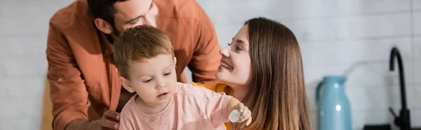 Hombre Abrazando Hijo Cerca Sonriendo Esposa Casa Bandera — Foto de Stock