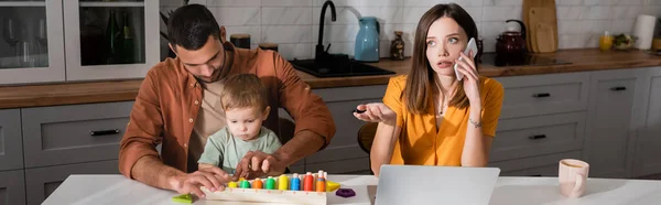 Freelancer Hablando Smartphone Cerca Laptop Familia Con Juego Educativo Banner — Foto de Stock