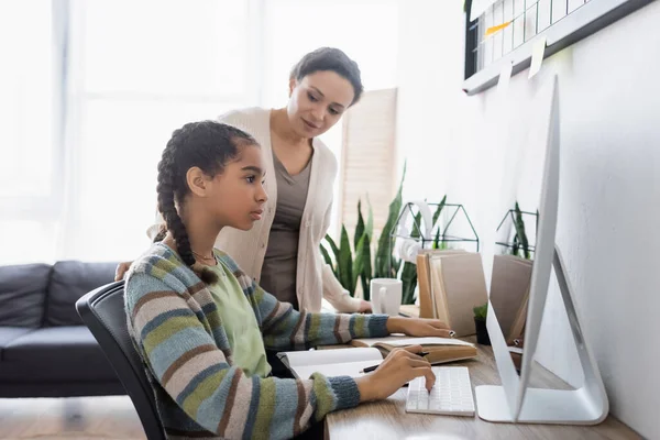 Afrikaans Amerikaanse Vrouw Zoek Naar Tiener Dochter Doen Huiswerk Computer — Stockfoto