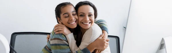 快乐的非洲裔美国妇女和少女拥抱在电脑显示器旁 高举横幅 — 图库照片