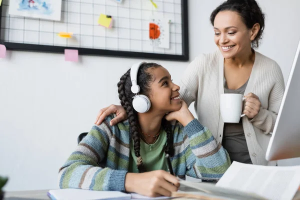 Africana Americana Menina Ouvir Lição Fones Ouvido Perto Sorrindo Mãe — Fotografia de Stock