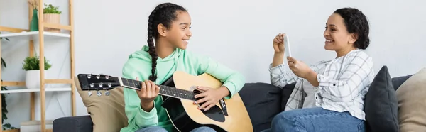 Afro Amerikai Mobiltelefonnal Fényképez Mosolygós Lánya Gitározik Otthon Banner — Stock Fotó