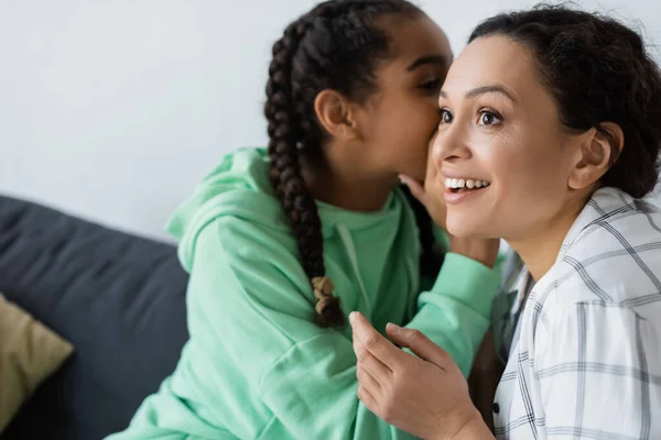 Afroamericana Chica Susurrando Oído Sonriente Madre Mientras Pasar Tiempo Casa — Foto de Stock