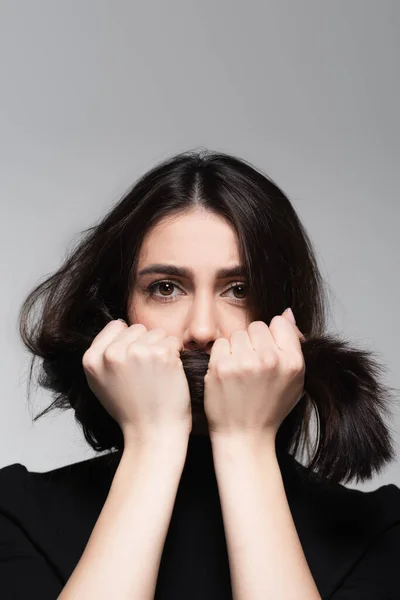 Junge Frau Bedeckt Mund Mit Glänzendem Haar Isoliert Auf Grau — Stockfoto