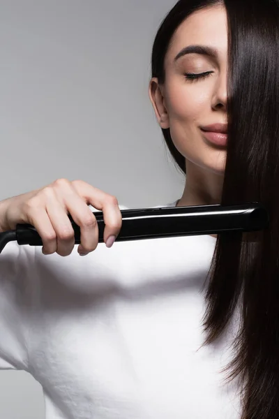 Mujer Joven Complacida Usando Plancha Pelo Aislado Gris — Foto de Stock