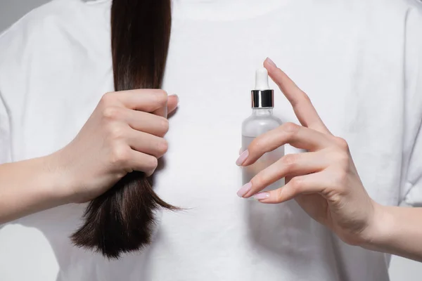 Vista Recortada Joven Mujer Sosteniendo Botella Con Aceite Cerca Pelo — Foto de Stock