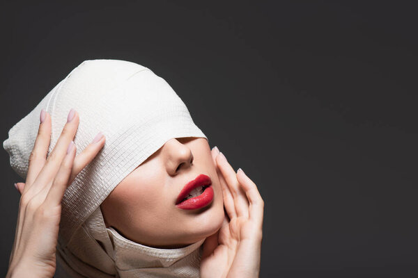 женщина в упругой повязке после пластической операции изолированы на сером