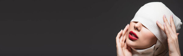женщина в упругой повязке с закрытыми глазами и красными губами, изолированными на сером, баннер