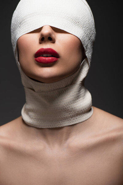 молодая женщина в упругой повязке с закрытыми глазами и красными губами, изолированными на сером
