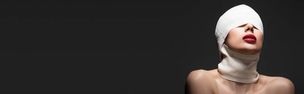 женщина в эластичной повязке с обнаженными плечами позирует изолированно на черном, баннер