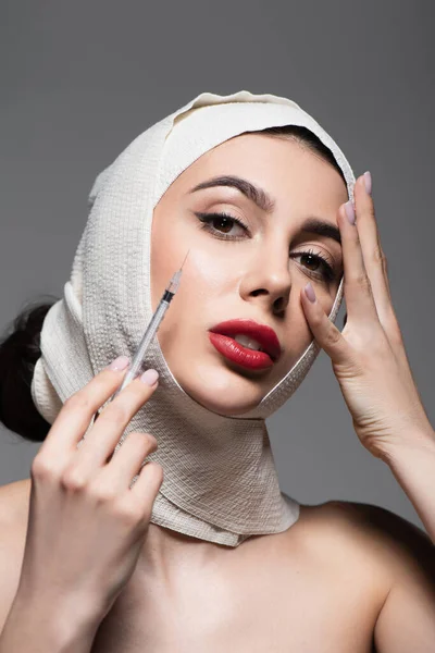 Kobieta Elastycznym Bandażu Strzykawce Trzymania Głowy Odizolowana Szaro — Zdjęcie stockowe