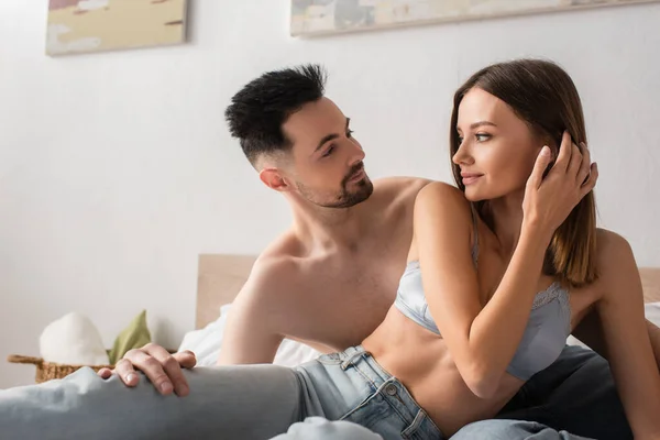 Mujer Seductora Sujetador Jeans Mirando Hombre Sin Camisa Dormitorio — Foto de Stock