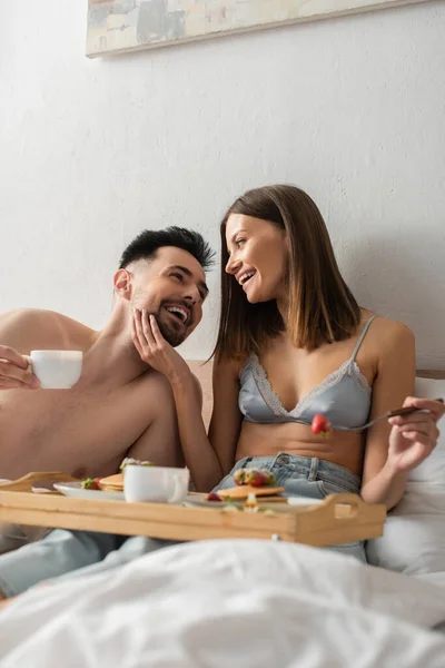 Happy Woman Bra Touching Face Shirtless Boyfriend Breakfast Bed — Stock Photo, Image
