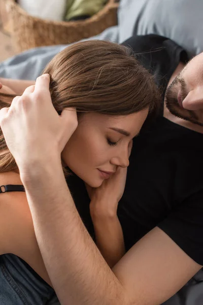 Man Black Shirt Embracing Young Woman Lying His Chest Closed — Stockfoto