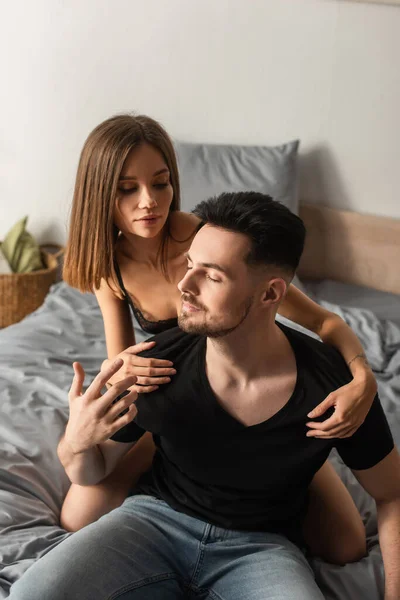 Seductive Woman Hugging Man Black Shirt Sitting Bedroom Closed Eyes — Stock Photo, Image