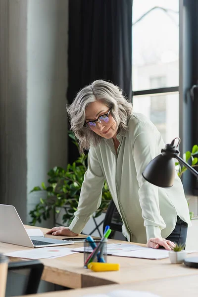 Reife Geschäftsfrau Schaut Büro Auf Papiere Der Nähe Von Geräten — Stockfoto