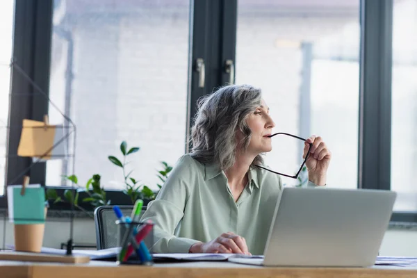 Pensive Zakenvrouw Met Bril Buurt Laptop Het Kantoor — Stockfoto