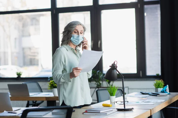 Mature Businesswoman Medical Mask Talking Smartphone Holding Document Office — Stock Photo, Image