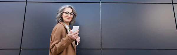 Middle Aged Businesswoman Coat Eyeglasses Holding Cellphone Paper Folder Outdoors — 图库照片