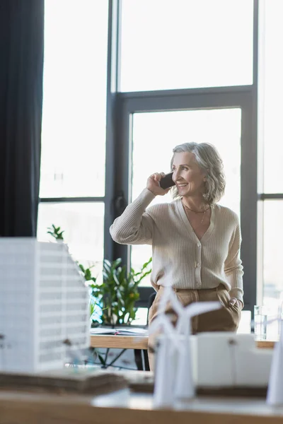 Positive Businesswoman Talking Cellphone Blurred Models Buildings Office — Stock Photo, Image