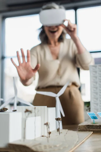 オフィスのVrヘッドセットのぼやけたビジネス女性の近くの建物のモデル — ストック写真