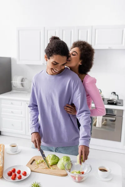 Young African American Woman Embracing Boyfriend Cooking Salad Coffee Vegetables — Stock Photo, Image