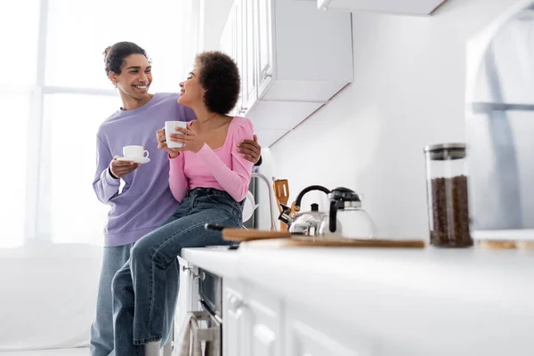 Joven Afroamericano Hombre Abrazando Novia Con Taza Encimera Cocina — Foto de Stock