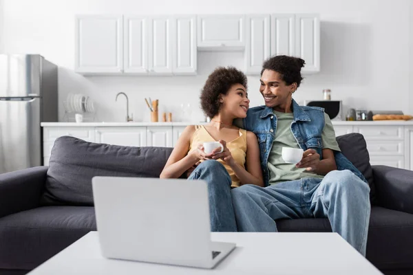 Young African American Couple Holding Cups Laptop Home — Stockfoto