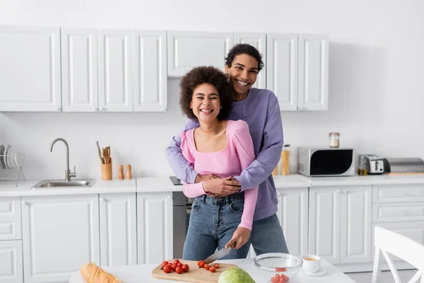 Smiling African American Man Hugging Girlfriend Vegetables Coffee Home — Stock Photo, Image