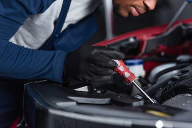 Atölyede araba motoru tamir eden Afrikalı Amerikalı tamircinin kısmi görüntüsü