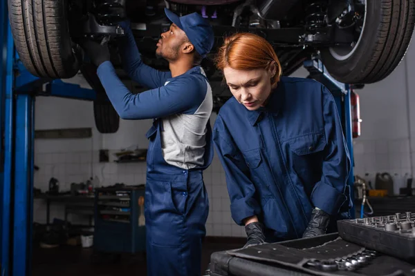 Mechanic Standing Tools African American Colleague Working Car Garage — Fotografia de Stock