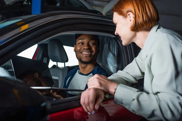 Smiling African American Mechanic Sitting Car Showing Laptop Happy Client — Stock Photo, Image