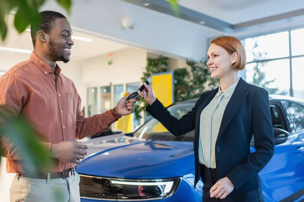 Smiling Car Dealer Giving Key Joyful African American Man Showroom — стоковое фото