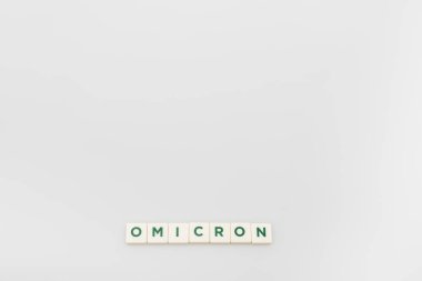 top view of white cubes with omicron lettering on grey background with copy space