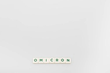 top view of white cubes with omicron lettering on grey background with copy space clipart