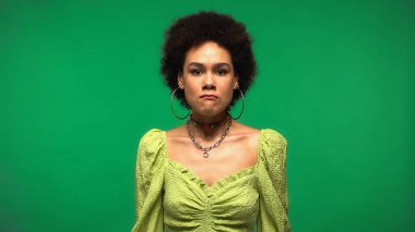 Kızgın genç Afro-Amerikalı kadın yeşilde izole edilmiş. 