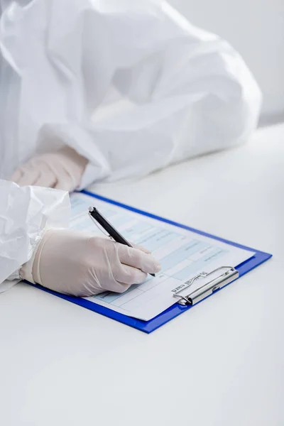 Partial View Blurred Doctor Hazmat Suit Writing Medical Card Clipboard — стоковое фото