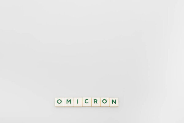 top view of white cubes with omicron lettering on grey background with copy space