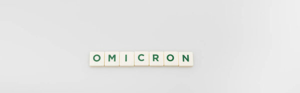 top view of white cubes with omicron lettering on grey background, banner