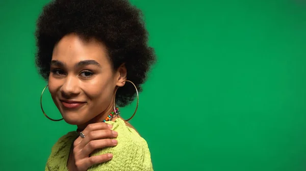 Smiling African American Woman Hoop Earrings Looking Camera Isolated Green — стоковое фото