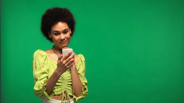 Young African American Woman Using Smartphone Isolated Green — Stockfoto