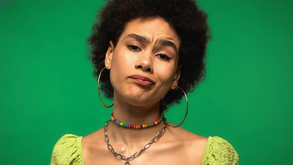 Displeased African American Woman Hoop Earrings Looking Camera Isolated Green — Stockfoto