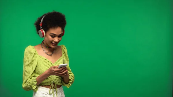 Happy African American Woman Wireless Headphones Using Smartphone Isolated Green — Stock Photo, Image
