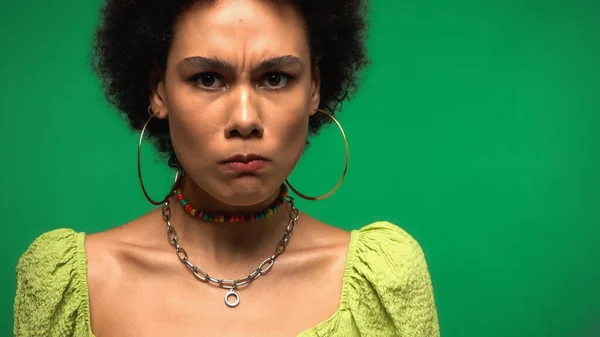 Upset African American Woman Hoop Earrings Looking Camera Isolated Green — Stockfoto