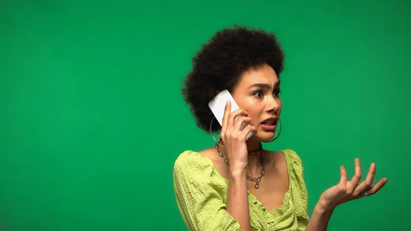 Mujer Afroamericana Disgustada Pendientes Aro Hablando Teléfono Celular Aislado Verde —  Fotos de Stock