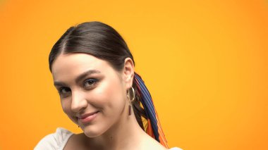 Sarıya izole edilmiş kameraya bakan esmer kadın portresi. 